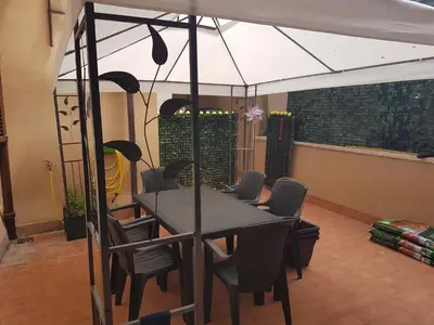 a table and chairs under an umbrella in a room at Bea&B in Rome