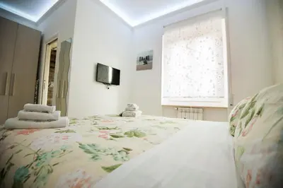 a bedroom with a large bed with a floral bedspread at St. Peter Station Suite in Rome