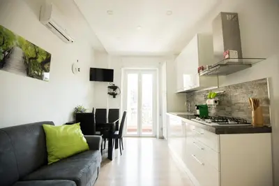 a living room with a couch and a kitchen at St. Peter Station Suite in Rome