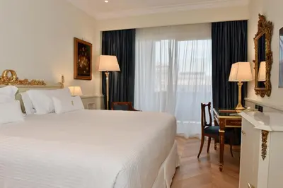 a hotel room with a bed and a desk and a window at Parco dei Principi Grand Hotel & SPA in Rome