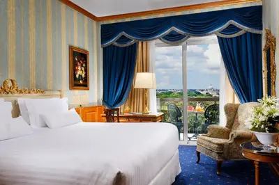 a bedroom with a bed and a chair and a window at Parco dei Principi Grand Hotel & SPA in Rome