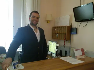 a man standing at a desk in a room at Hotel Lazzari in Rome
