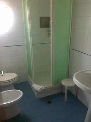 a bathroom with a shower and a toilet and a sink at Hotel Lazzari in Rome