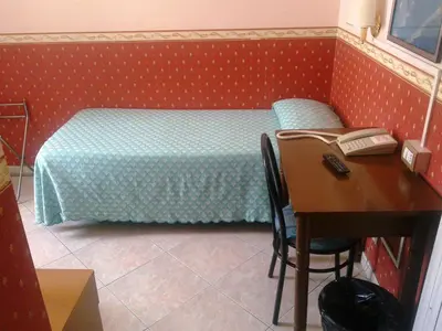 a bedroom with a bed and a desk with a desk at Hotel Lazzari in Rome