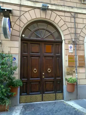 a large wooden door on the side of a building at Hotel Lazzari in Rome