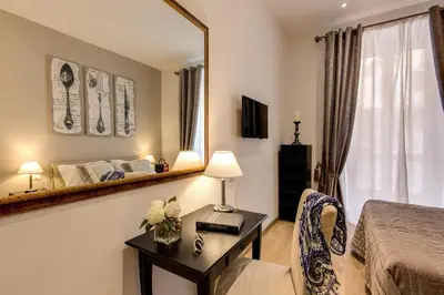 a bedroom with a bed and a table with a mirror at Sweet Stay In Rome in Rome