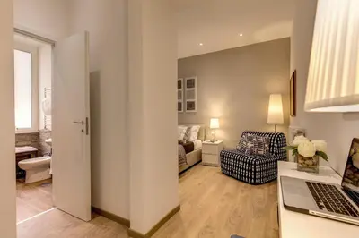 a living room with a couch and a desk with a laptop at Sweet Stay In Rome in Rome