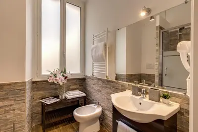 a bathroom with a sink and a toilet and a mirror at Sweet Stay In Rome in Rome