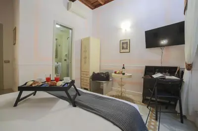 a room with a bed and a table and a television at La Maison Dell'Orologio in Rome