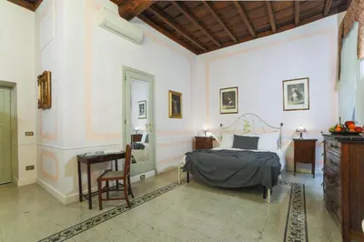 a bedroom with a bed and a table and a desk at La Maison Dell'Orologio in Rome
