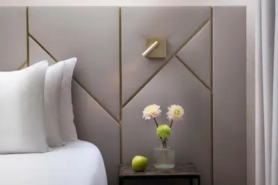 a bedroom with a bed and a vase with flowers on a table at NH Collection Roma Giustiniano in Rome