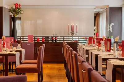a dining room with tables and chairs in a restaurant at NH Collection Roma Giustiniano in Rome