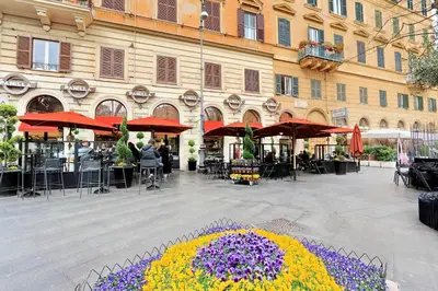 a courtyard with tables and chairs and flowers in front of a building at Parrotshouse in Rome