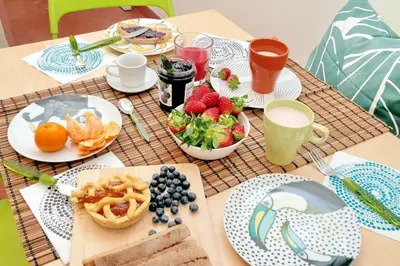 a table topped with plates of food and fruit at Parrotshouse in Rome