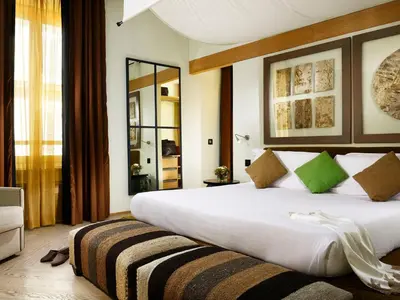 a bedroom with a large white bed with green pillows at Babuino 181 - Small Luxury Hotels of the World in Rome