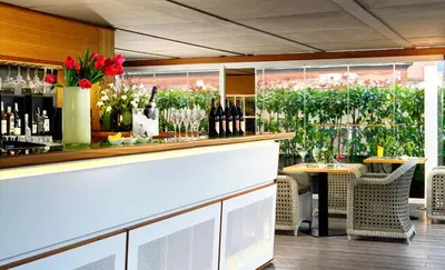 a bar with bottles of wine and a table at Babuino 181 - Small Luxury Hotels of the World in Rome