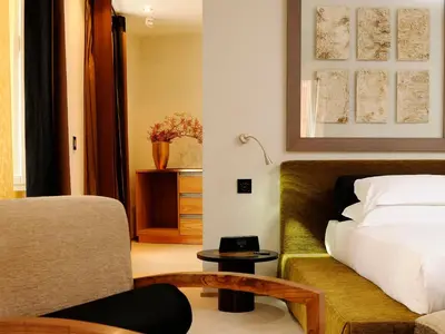 a bedroom with a bed and a couch and a chair at Babuino 181 - Small Luxury Hotels of the World in Rome