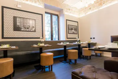 a dining room with tables and chairs and a bench at Deseo Home Guest House in Rome