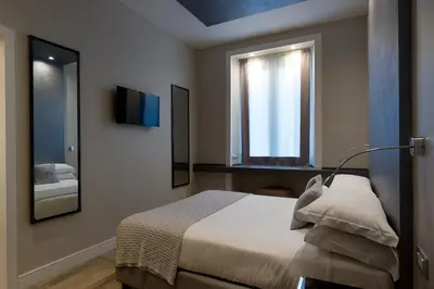 a bedroom with a bed with a mirror and a window at Deseo Home Guest House in Rome