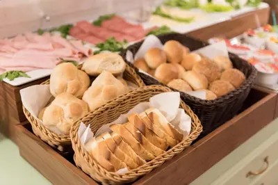 a buffet with baskets of bread and pastries on a table at Deseo Home Guest House in Rome