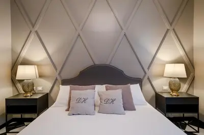 a bedroom with a bed with two lamps on tables at Deseo Home Guest House in Rome