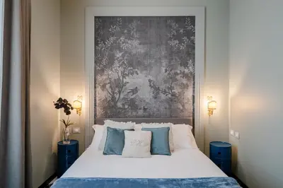 a bedroom with a bed with a painting on the wall at Deseo Home Guest House in Rome