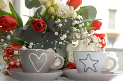 two cups on a table with a vase of flowers at TinkerBell GuestHouse in Rome