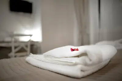a pile of towels sitting on top of a bed at TinkerBell GuestHouse in Rome