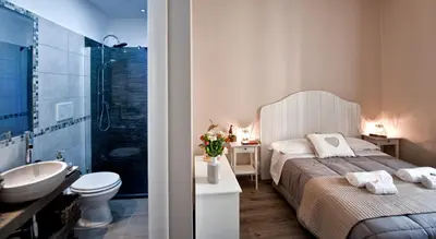 a bedroom with a bed and a bathroom with a sink at TinkerBell GuestHouse in Rome