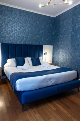 a large bed in a room with a blue wall at Vatican Plaza in Rome