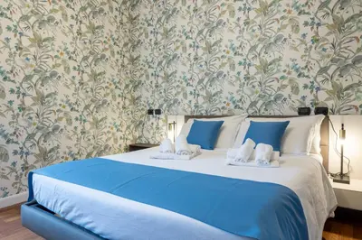 a bedroom with a blue bed with a floral wallpaper at Vatican Plaza in Rome