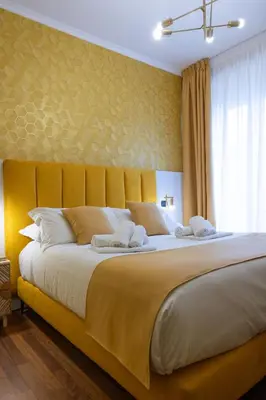 a bedroom with a large bed with a yellow headboard at Vatican Plaza in Rome