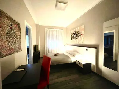a hotel room with a bed and a desk and a table at Your House By Ale in Rome