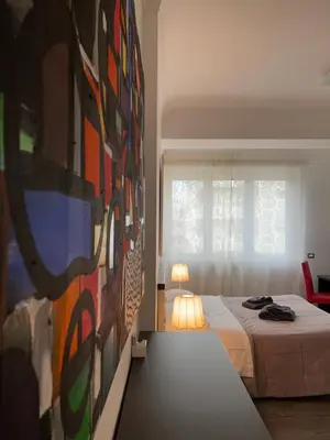 a bedroom with a bed and a painting on the wall at Your House By Ale in Rome