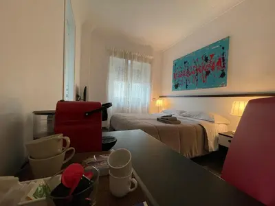 a hotel room with a bedroom with a bed and a table at Your House By Ale in Rome