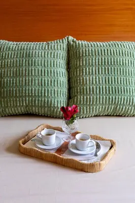 a tray with two cups and a vase with a flower at B&B A Casa di Tiziana - Roma in Rome