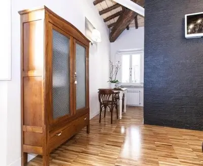 a large wooden cabinet in a room with a table at Urbana 33 in Rome