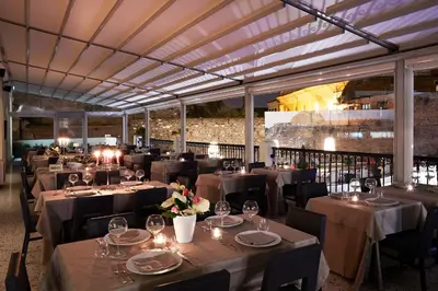 a dining room with tables and chairs with lights at Hotel The Building in Rome