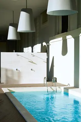 a swimming pool in a room with two lights at Hotel The Building in Rome