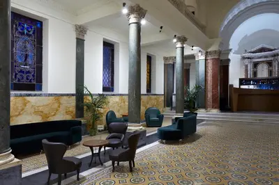 a lobby with chairs and tables in a building at Hotel The Building in Rome