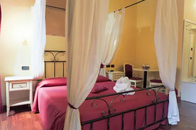 a bedroom with a red bed with curtains at Sweet Dream Trevi in Rome