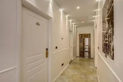 a hallway with white walls and a white door at Relais Conte Di Cavour De Luxe in Rome