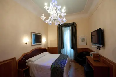 a hotel room with a bed and a chandelier at Relais Conte Di Cavour De Luxe in Rome