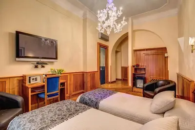 a bedroom with two beds and a flat screen tv at Relais Conte Di Cavour De Luxe in Rome