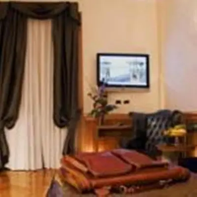 a living room with a couch and a television at Relais Conte Di Cavour De Luxe in Rome