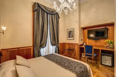 a bedroom with a bed and a chandelier at Relais Conte Di Cavour De Luxe in Rome