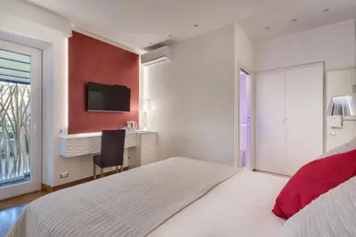 a bedroom with a bed and a desk and a television at Shali Luxury Suite Spagna in Rome
