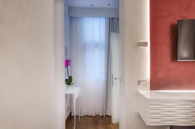 a bathroom with a white sink and a vase on a table at Shali Luxury Suite Spagna in Rome