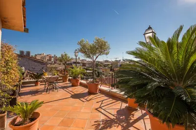 a patio with potted plants and tables on a roof at Hotel La Lumiere Di Piazza Di Spagna in Rome