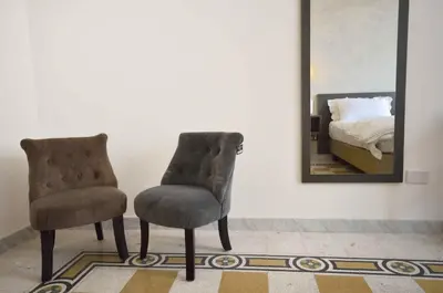 a bedroom with two chairs and a mirror at Room with a view 105 in Rome